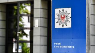Ein Schild weist auf die "Polizei Land Brandenburg" hin.(Quelle:dpa/J.Kalaene)