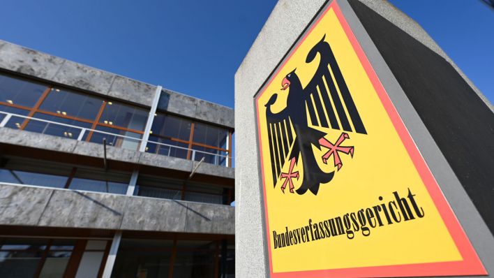 Vor dem Bundesverfassungsgericht hängt ein Hinweisschild mit der Aufschrift Bundesverfassungsgericht und dem Bundesadler.