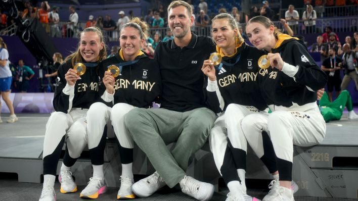 Der ehemalige Basketballspieler Dirk Nowitzki feiert mit die Goldmedaillengewinnerinnen Svenja Brunckhorst (l-r), Marie Reichert, Sonja Greinacher und Elisa Mevius nach der Siegerehrung (Bild: dpa/ Maximilian Specht)