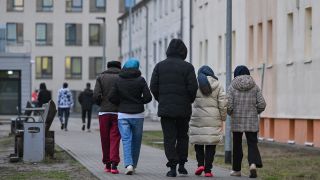 Migranten gehen über das Gelände der Zentralen Erstaufnahmeeinrichtung für Asylbewerber (ZABH) des Landes Brandenburg in Eisenhüttenstadt.