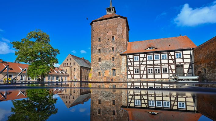 Die im Jahr 1316 erstmals urkundlich erwähnten Burg Beeskow spiegelt sich in einer Pfütze. (Quelle: dpa/Patrick Pleul)