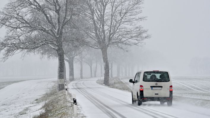Ein Auto fährt auf einer schneebedeckten Brandenburger Landstraße (Bild: dpa/Patrick Pleul)