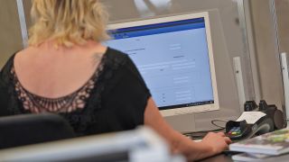 Symbolbild:Eine Bibliothekarin sitzt in der Bibliothek des Bezirksamts Mitte in der Müllerstraße vor einem Computer.(Quelle:picture alliance/dpa/J.Carstensen)