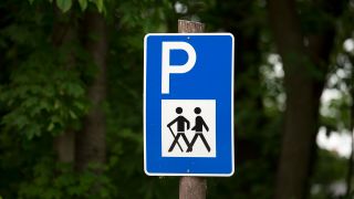 Ein Parkplatzschild für Wanderer steht in Trebus (Brandenburg) auf einem Parkplatz am Trebuser See. (Quelle: dpa/Marc Tirl)