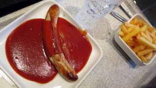 Ein Tablett mit einer Currywurst mit Pommes Frites steht in einer Kantine, Archivbild (Quelle: DPA/Martin Gerten)