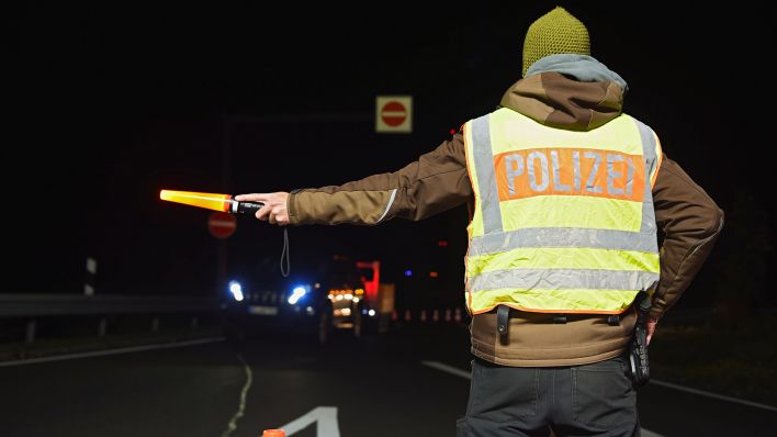 Symbolbild: Ein Polizist leitet am 13.10.2019 an einer Kontrollstelle der Polizei an der A93 die Autos um. (Quelle: dpa/Nicolas Armer)