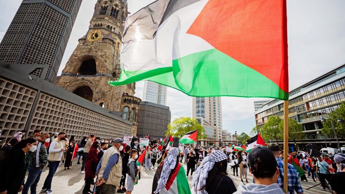 Symbolbild:Teilnehmer einer Kundgebung haben sich mit einer palästinensichen Flagge auf dem Breitscheidplatz vor der Kaiser-Wilhelm-Gedächtnis-Kirche versammelt.(Quelle:dpa/C.Soeder)