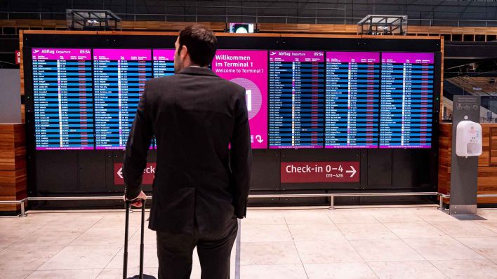 Symbolbild: Ein Mann steht bei Warnstreiks von Verdi am Hauptstadtflughafen Berlin-Brandenburg BER vor der Anzeige mit gestrichenen Flügen. Beim Amtsgericht Königs Wusterhausen, das für den Hauptstadtflughafen BER zuständig ist, landen immer mehr Klagen gegen Airlines. (Quelle: dpa)