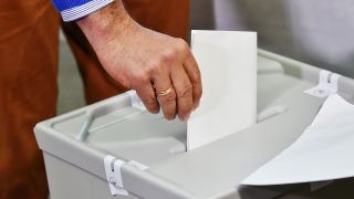 Symbolbild:Ein verschlossener Wahlumschlag wird in eine Urne gesteckt.(Quelle:picture alliance/dpa-Zentralbild/P.Pleul)