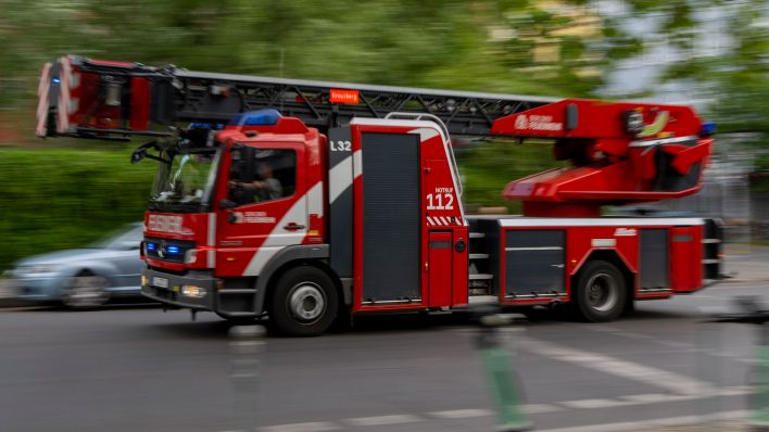 Symbolbild: Ein Feuerwehrauto fährt mit Blaulicht zum Einsatz. (Quelle: dpa/Skolimowska)