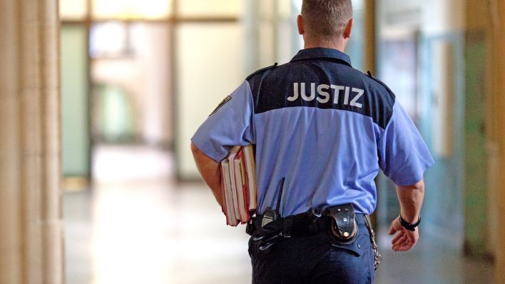 Symbolbild:Ein Justizbeamter trägt im Flur des Kriminalgerichts Moabit in Berlin Akten unter dem Arm.(Quelle:picture alliance/dpa/F.Schuh)