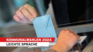 Symbolbild Kommunalwahl 2024 Leichte Sprache: Wählerinnen stecken ihren Wahlbrief in die Urne.(Quelle:dpa/David Vincent)