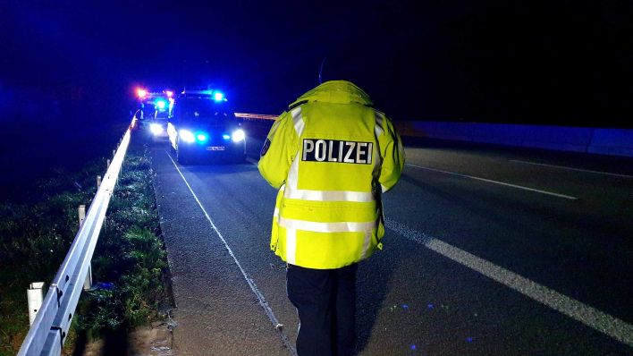 Symbolbild: Ein Polizist läuft auf der Autobahn auf dem Seitenstreifen umher. (Quelle: dpa/Stähle)