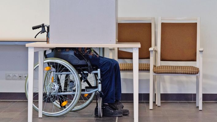 Archivbild: Ein Rentner im Rollstuhl gibt in der Wahlkabine in einem Wahllokal seine Stimme ab. (Quelle: dpa/Michael)