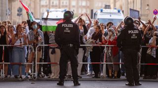 Polizisten stehen hinter einer Absperrung vor Protestierenden der Berliner Humboldt-Universität.(Quelle:dpa/C.Gateau)