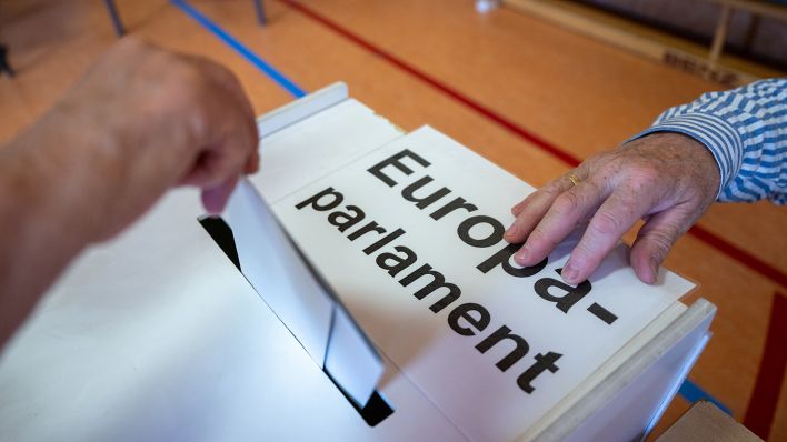 Ein Wahlberechtigter wirft amm 09.06.2024 in einem Wahllokal seinen Stimmzettel in eine Wahlurne mit der Aufschrift „Europaparlament“. (Quelle: dpa/Monika Skolimowska)