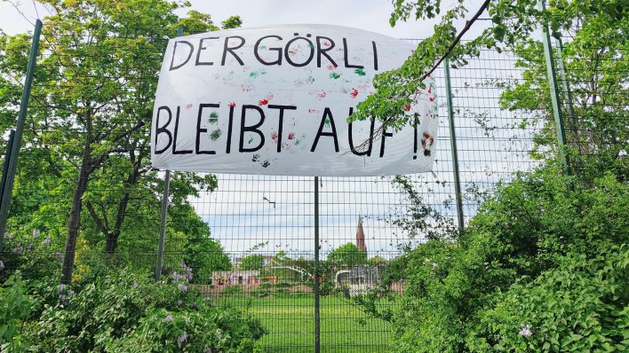 Auf einem Banner steht "Der Görli bleibt auf" aus Protest gegen den geplanten Zaun (Quelle: dpa)