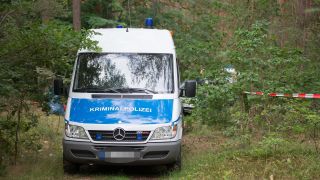 Archivbild: Ein Wagen der Kriminalpolizei steht in einem Wald bei Oranienburg. Hier fanden Besucher einer dortigen Bunkeranlage im Juli 2021 die Leiche einer jungen Frau. (Quelle: dpa/TNN)