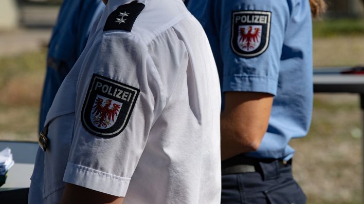 Symbolbild: Polizisten stehen auf dem Gelände der ehemaligen Polizeiwache in Oranienburg (Brandenburg) zusammen. (Quelle: dpa/Zinken)