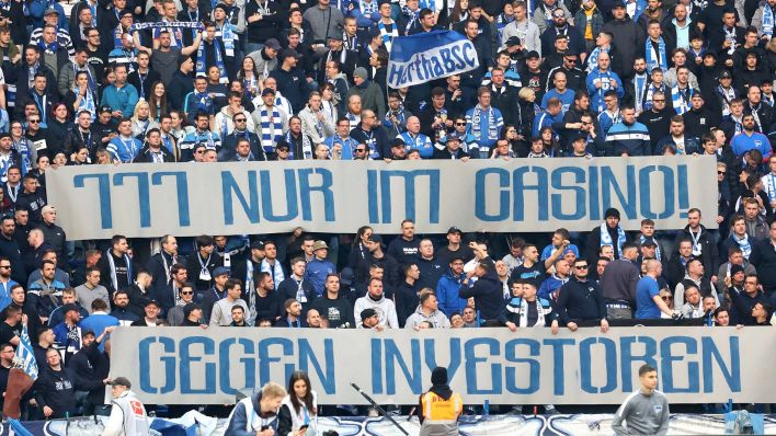 Fans in der Ostkurve Hertha BSC halten Spruchbänder hoch (Quelle: IMAGO / Nordphoto)