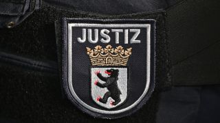 Symbolbild: Das Logo auf der Uniform eines Justizbeamter im Berliner Landgericht.(Quelle:picture alliance/dpa/S.Stache)