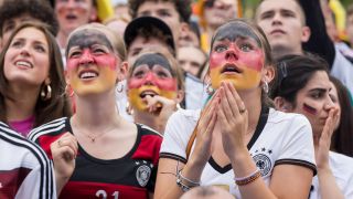 Fußballfans in der Fanzone am Brandenburger Tor (Bild: IMAGO/PIC ONE)