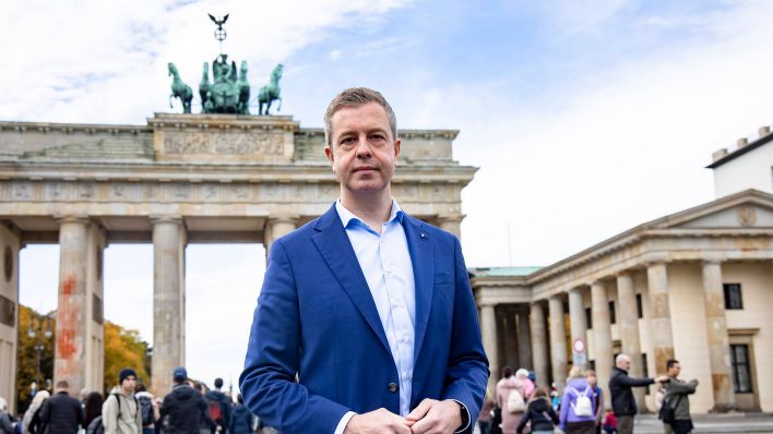 Finanzsenator Stefan Evers steht vor dem Brandenburger Tor in Berlin. (Quelle: imago-images/Emmanuele Contini)