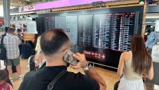 Menschen schauen auf eine Anzeigetafel am Flughafen BER, wo am 19.07.2024 der Flugverkehr wegen einer technischen Störung beeinträchtigt ist (Quelle: rbb/Georg-Stefan Russew)