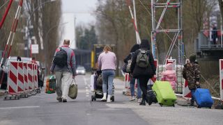 Ukrainische Flüchtlinge verlassen mit ihrem Gepäck die Flüchtlingsunterkunft. (Quelle: dpa/Marcus Brandt)