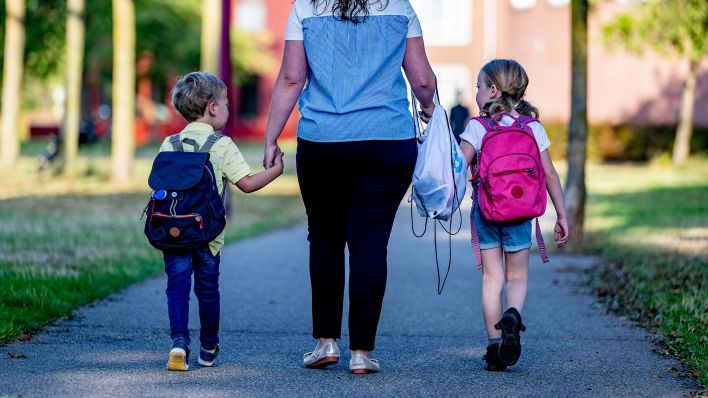 Eine Mutter mit zwei Grundschulkindern. (Quelle: dpa)