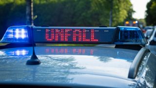 Symbolbild:Ein Einsatzfahrzeug, Streifenwagen, der Polizei steht mit Blaulicht und dem Schriftzug Unfall im Display an einem Unfallort.(Quelle:picture alliance/Fotostand/Gelhot)