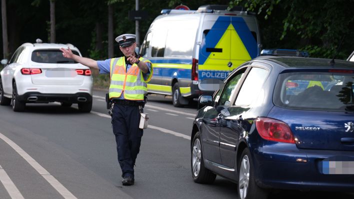 Symbolbild: Ein Polizist winkt bei einer Kontrollstelle ein Fahrzeug heraus. Etwa 80 Beamte sind bei einer Schwerpunktkontrolle zur Fahrtüchtigkeit im Einsatz, um Verkehrsteilnehmer auf Alkohol und Drogen zu testen. (Quelle: dpa/Winnow)