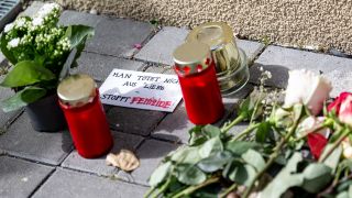 Blumen und Kerzen liegen nach einem tödlichen Messerangriff vor einem Hauseingang in Berlin-Friedrichsfelde neben einem Zettel mit der Aufschrift „Man tötet nicht aus Liebe - Stoppt Femizide“. (Quelle: picture alliance/dpa/Fabian Sommer)