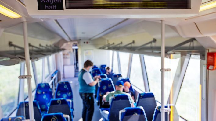 Symbolbild:Eine Zugbegleiterin verkauft Fahrkarten im Triebwagen der Ostdeutschen Eisenbahngesellschaft (ODEG).(Quelle:picture alliance/dpa-Zentralbild/J.Büttner)