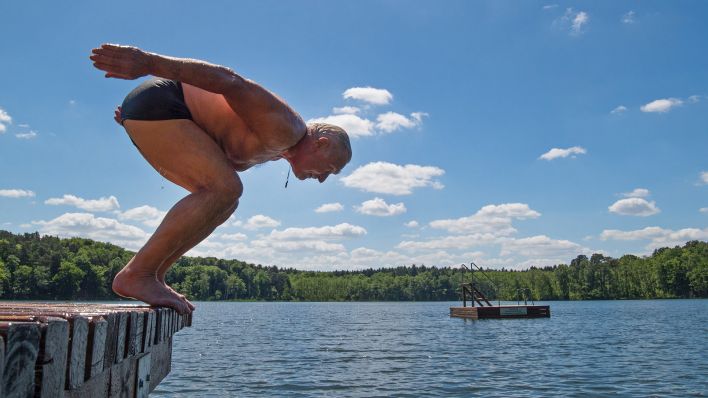 Symbolbild:Ein älterer Mann springt von einem Steg in das Wasser des Trepliner Sees nahe Treplin (Brandenburg).(Quelle:picture alliance/dpa/P.Pleul)