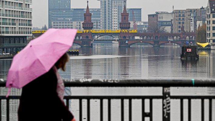 Archivbild: Die Oberbaumbrücke spiegelt sich am 22.12.2022 bei trüben, regnerischem Wetter im Wasser der Spree (Quelle: dpa / Jens Kalaene).