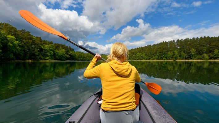 Symbolbild:Eine Paddlerin in einem Gewässer bei Rheinsberg.(Quelle:imago images/J.Krauthöfer)