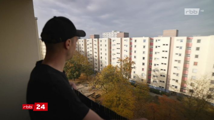 Mann blick aus dem Balkon