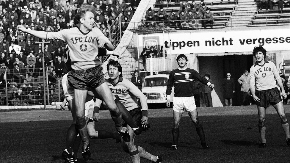 Archivbild: Der Leipziger Mittelfeldspieler Uwe Bredow (l, oben) steigt vor seinen Teamgefährten Wolfgang Altmann (3.v.r) und Peter Schöne (r) sowie BFC-Verteidiger Artur Ullrich (2.v.r.) zum Kopfball hoch. (Quelle: dpa/Uhlemann)