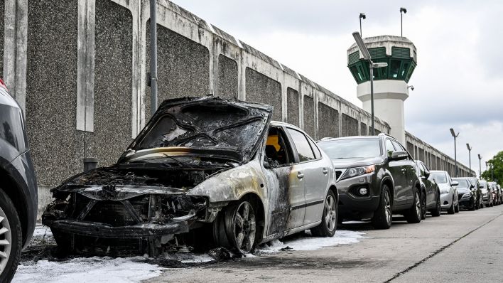 Archivbild: Ein ausgebranntes Auto steht im Friedrich-Olbricht-Damm vor der Justizvollzugsanstalt Plötzensee. (Quelle: dpa/Kalaene)