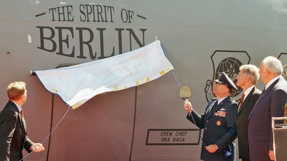 In Anwesenheit von US-Präsident Bill Clinton (2.v.r.) und Kanzler Helmut Kohl (r) enthüllen Bürgermeister Eberhard Diepgen (l) und der US-Luftwaffengeneral Jumper am Donnerstag (14.5.98) in Berlin den Namen der Maschine "The Spirit of Berlin". (Quelle: picture alliance/dpa/Wolfgang Kumm)