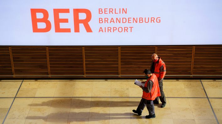 22.10.2020, Brandenburg, Schönefeld: Zwei Mitarbeiter gehen im Terminal 1 des Flughafens Berlin Brandenburg. (Quelle: dpa/Soeren Stache)