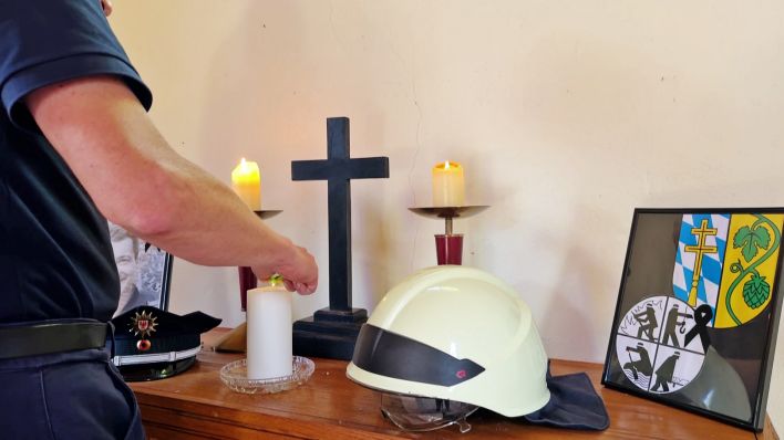 Ein Polizist zündet eine Kerze in der Blaulichtkirche an.(Quelle:rbb)