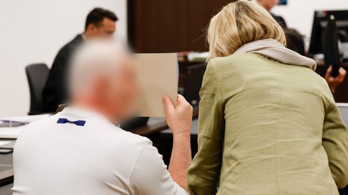 Symbolbild: Ein Angeklagter spricht zu Beginn des Prozesses im Gerichtssaal des Landgerichts mit einer Übersetzerin. (Quelle: dpa/Löb)