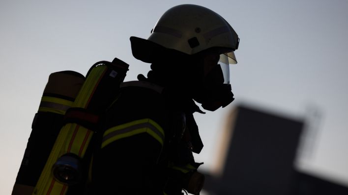 Symbolbild: Ein Feuerwehrmann in Atemschutzausrüstung am 11.01.2024 bei einem Wohnungsbrand in Deggendorf. (Quelle: dpa-Bildfunk/Rolf Vennenbernd)