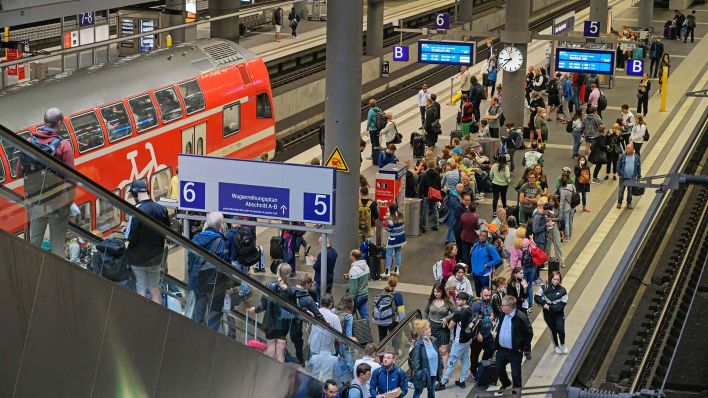 Symbolbild:Passagiere warten auf dem unteren Bahnsteig des Berliner Hauptbahnhofs.(Quelle:imago images/Schöning)