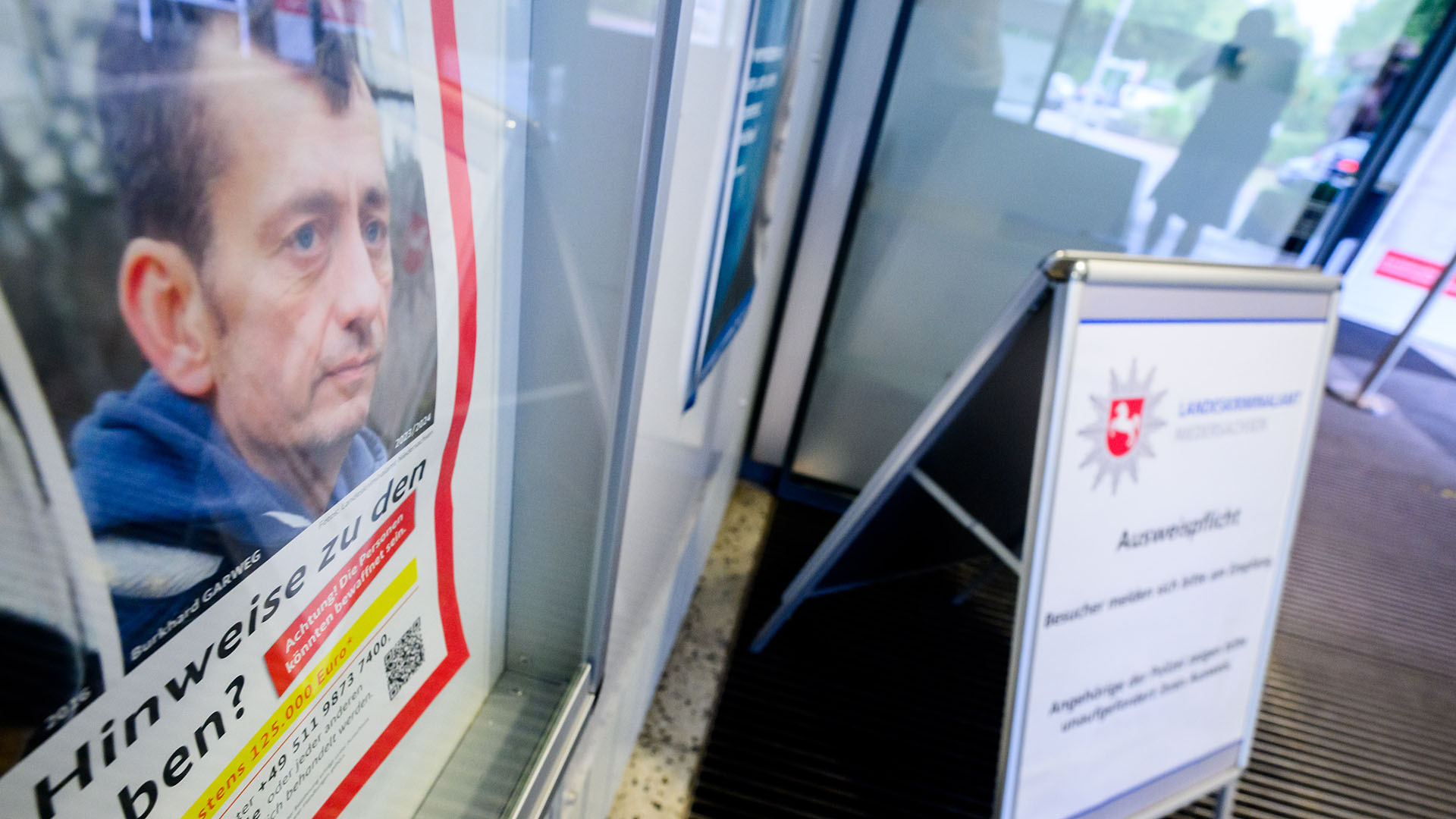 Ein Fahndungsplakat mit einem Foto von Burkhard Garweg hängt im Eingangsbereich vom Landeskriminalamt Niedersachsen. (Quelle: dpa/Julian Stratenschulte)