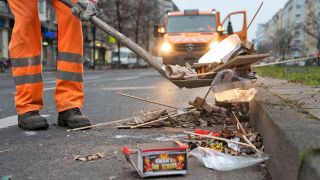 Archivbild: Ein Mitarbeiter der Berliner Stadtreinigung BSR räumt am 01.01.2020 abgebranntes Feuerwerk von einer Straße. (Quelle dpa-Bildfunk/Christophe Gateau)