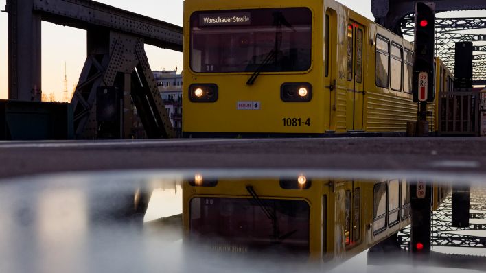 Eine U-Bahn der BVG fährt in einen Bahnhof ein und spiegelt sich in einer Pfütze. Bild: picture alliance / SZ Photo, Jürgen Heinrich