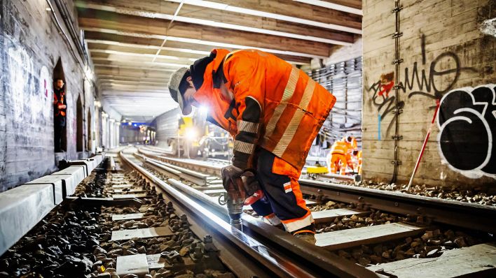 Archivbild:Ein Arbeiter führt bei einer Baustellen-Begehung des Nord-Süd-Tunnels der Berliner S-Bahn Gleisarbeiten am 05.02.2024 durch.(Quelle:picture alliance/dpa/C.Soeder)